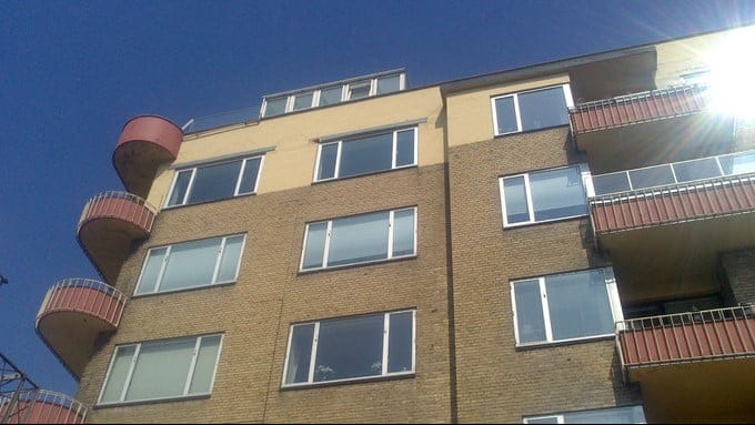 Moderne lejlighedsbygning med altaner under blå himmel