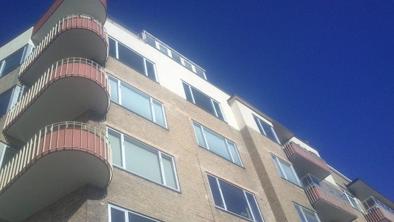 Moderne lejlighedsbygning med altaner under blå himmel