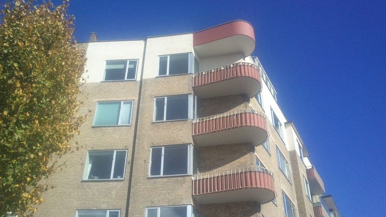 Moderne lejlighedsbygning med altaner under blå himmel