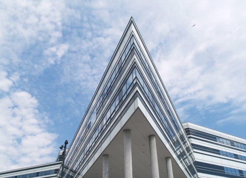 Moderne kontorbygning med glasfacade under blå himmel