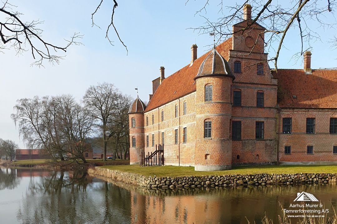Historic brick castle beside a calm moat