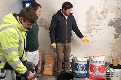 Workers preparing construction materials indoors