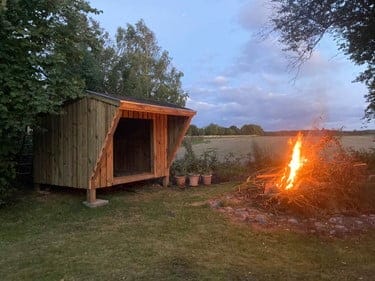 Træ shelter ved bålplads i naturen