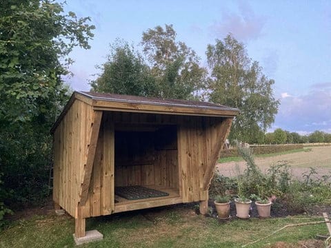 Træ shelter i natur omgivet af træer