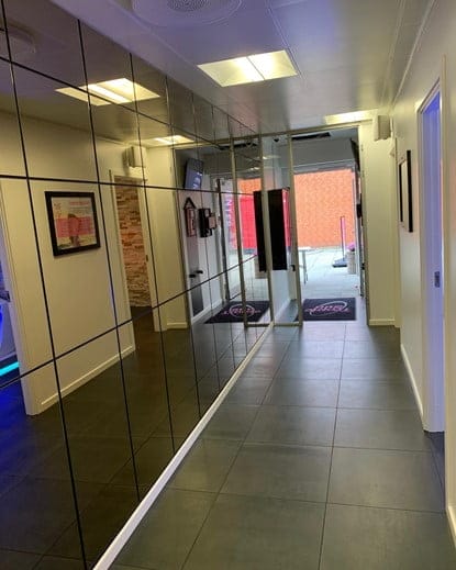 Modern hallway with mirrored wall and tiled floor