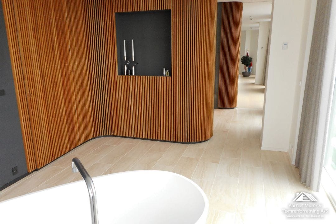 Moderne badeværelse med træpaneler og fritstående badekar